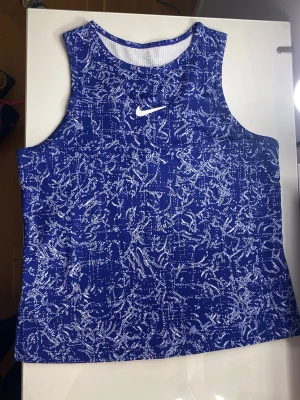 Nike träningslinne  - Blått träningslinne med vita detaljer. Superfin. Använd 2ggr, jättebra skick.💙Storlek M barnstorlek, passar även XS 🥰