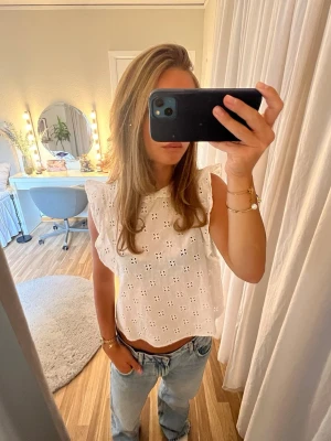 Vit blus - Vit blus med söta detaljer och volang längs med armar och krage 