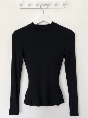 Fin svart pieces ribbad långärmad topp  - Säljer en svart ribbad långärmad topp från Pieces i storlek XS. Toppen har en tight passform, hög hals och är tillverkad i ett mjukt stretchigt material. Passar perfekt till vilken outfit som helst.