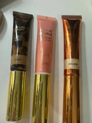 Glow Edit Highlighter Aglow trio - Glow Edit highlighter i färgen Aglow med krämig formula. Kommer i en snygg tub med guldig kork och metallisk finish. Perfekt för att ge huden en fräsch lyster och highlighta ansiktets höga punkter.