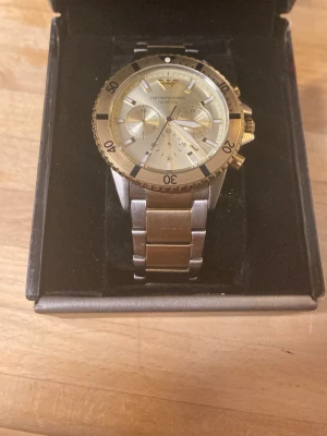 Emporio Armani Diver Chrono Silver/Pale gold AR11606 - En fin och oanvänd Emporio Armani klocka av rostfritt stål i stål och guld färger. Orginal box kommer med tillsammans med alla uppgifter!