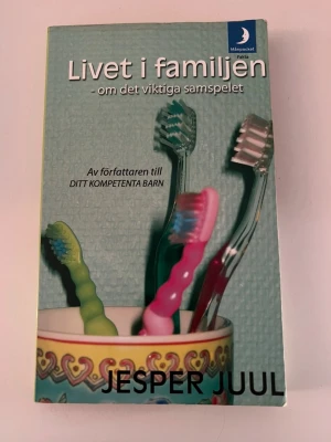 Livet i familjen av Jesper Juul - En pocketbok av Jesper Juul om familjeliv och samspel. Omslaget visar färgglada tandborstar i en mugg mot en ljusblå bakgrund. Boken tar upp relationer, ansvar och ledarskap i familjen. Perfekt för dig som vill förstå mer om dynamiken i familjen.