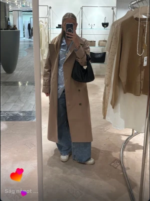Beige klassisk trenchcoat - Stilren beige trenchcoat med dubbelknäppning och  krage. Använd typ tre gånger så som ny!! 🥳Den är storlek S men den är oversized!! Tidlös design med raka linjer och bälte i midjan för extra edge.
