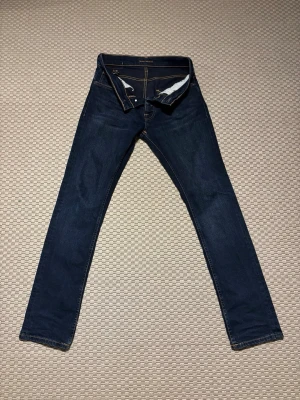Nudie Jeans Grim Tim - Säljer dessa sjukt snygga Nudie Jeans i modellen Grim Tim. Färgen är New Ink och kostar 1600kr nya. Skicket är i 9/10 och visar inga defekter alls. W30/L32