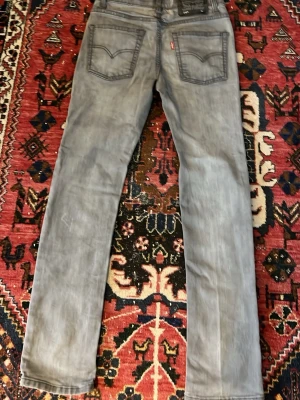 Grå Levi's 510 slim jeans - Säljer ett par grå Levi's 510 slim jeans med klassiska bakfickor och svart patch bak i midjan. Jeansen har raka ben och är tillverkade i ett mjukt denimtyg. Perfekta för dig som gillar en clean och stilren look.