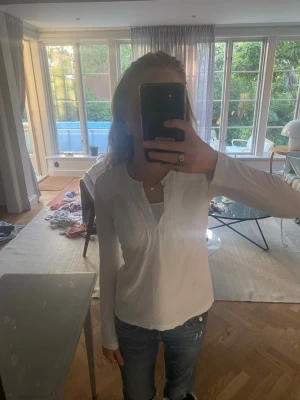 Vit blus från Massimo Dutti - Säljer en vit blus från Massimo Dutti med v-ringning och fina detaljer vid axlar och hals. Blusen har lång ärm och är gjord i mjuk bomull. Passar som en xs. Jag säljer den eftersom den inte är min stil längre. Kan absolut diskutera pris💖
