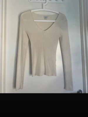 Lång ärmadtröja  - Lpng ärmad beige tröja med V ringning från H&M. Passar till vardagslooken 