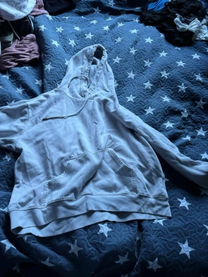 Ljusgrå hoodie med ficka XL - En ljusgrå hoodie med stor känguruficka framtill och justerbar dragsko i huvan. Hoodien har ribbade muddar vid ärmslut och nederkant. Perfekt för en chill och avslappnad stil. Materialet känns mjukt och bekvämt mot huden.