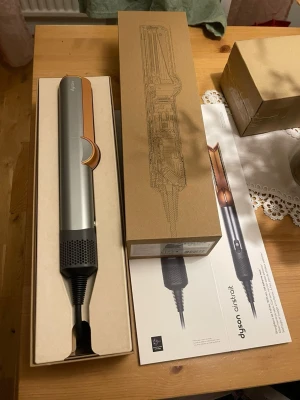 Dyson Airstrait hårstyler silver/koppar - Säljer en Dyson Airstrait hårstyler i snygg silver och kopparfärg. Kommer i originalförpackning med tillhörande värmeskyddsmatta. Perfekt för att styla håret snabbt och enkelt med modern teknik.