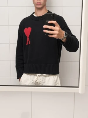 Mörkgrå stickad tröja med rött hjärta - Snygg mörkgrå stickad tröja med ett stort rött hjärta och bokstaven A på bröstet. Tröjan har ribbade muddar vid ärmslut och nederkant samt en högre krage. Tillverkad i Portugal. Perfekt för dig som gillar trendiga detaljer.