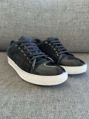 Lanvin cap toe suede/patent sneckers. Uk 8 passar 42-43 - Säljer nu dessa riktigt schyssta skor från lanvin Paris. Model namn - lanvin DBB1 cap toe. Nypriset  på dessa är 5000kr och de är självklart äkta. Skicket är riktigt bra, notera att sulkräm har andvänts.