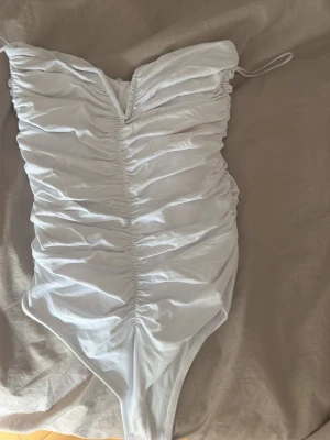 Body - En vit body med v ringning vid bysten. Den är oanvänd och lappen är kvar. Från zara❤️den ser liten ut på bild men är väldigt mjukt och stretchigt material 