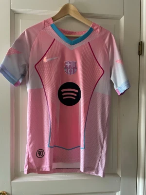 Rosa FC Barcelona matchtröja - Snygg rosa FC Barcelona matchtröja med Lamine Yamal och nummer 19 på ryggen. Tröjan har korta ärmar, blå och vita detaljer samt klubbmärke och sponsorlogga framtill. Tillverkad i lätt och ventilerande funktionsmaterial, perfekt för fotboll eller träning.                                        Priset går att diskutera vid en snabb affär.       Kom med frågor.