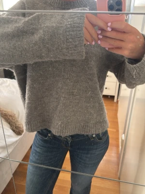 Grå stickad tröja  - Mysig grå stickad tröja med rund hals och långa ärmar. Från Gina 