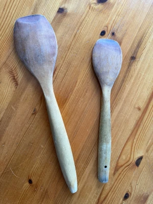 Två träslevar i olika storlekar - Säljer två klassiska träslevar med rundade kanter, perfekta för matlagning och bakning. Slevarna är tillverkade i ljust trä och har ergonomiska handtag. Ena sleven har ett litet hål i handtaget för upphängning. Passar bra i köket för olika ändamål.