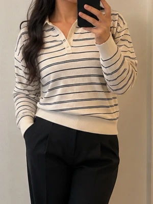 Randig vit långärmad tröja - Snygg vit långärmad tröja med tunna svarta horisontella ränder och krage. Tröjan har knappar vid halsen och ribbade muddar vid ärmslut och nederkant. Perfekt för en avslappnad men stilren look. Storlek xs men det passar också som s m