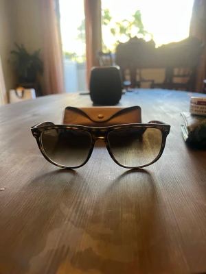 Ray-Ban boyfriends solglasögon brun - Säljer ett par klassiska Ray-Ban boyfriend solglasögon med brunmelerad båge och mörka glas. Snygg retrostil som passar till allt. Kommer med originalfodral.