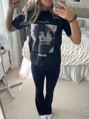 Svart Lady Gaga t-shirt - Cool svart t-shirt med stort Lady Gaga-tryck framtill. T-shirten har korta ärmar, rund hals och en relaxed passform. Perfekt för dig som gillar musik och vill ha en statement tee i garderoben.