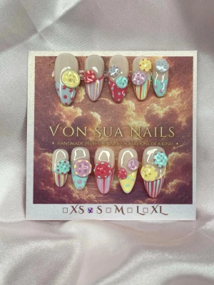 ButtonPop (S);Medium Almond - Ett lekfullt statement-set fyllt av färg, ränder, prickar och tredimensionella knappar. Varje knapp är skulpterad för hand av mig och individuellt handmålad, vilket gör varje detalj unik. Hela designen är skapad för hand och kombinerar olika mönster och färger för en maximalistisk, quirky look.S: 15 mm, 11,5 mm, 12 mm, 11 mm, 9 mm 