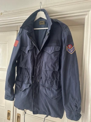 Field jacket Ralph Lauren - Bra skick utöver lite slitningar på bilden och två synliga lagningar som jag tycker bara gör jackan snyggare. Storlek medium