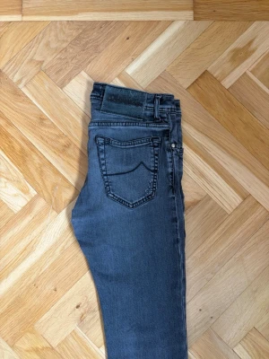 Jacob Cohen jeans - Säljer ett par jacob Cohen jeans med coola slitningar och klassisk femficksdesign. Jeansen har normalhög midja och smal passform hela vägen ner. Perfekta för dig som gillar en avslappnad men trendig stil. Nerkortade till 92 längd 