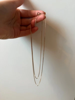 Tunt guldhalsband i minimalistisk stil - Säljer ett tunt och elegant halsband i guldton med enkel kedja och klassiskt lås. Halsbandet har en minimalistisk design som passar perfekt till alla outfits. Använda men fint