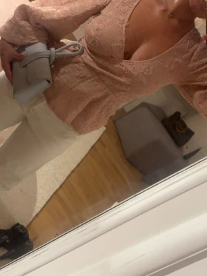 Rosa spetsblus med v-ringning ( NA-KD )  - Säljer en romantisk rosa spetsblus med djup v-ringning och långa ärmar. Blusen har figurnära passform och fina spetsdetaljer som ger en elegant look. Perfekt att styla med jeans eller kjol för en trendig outfit. ( Ny med prislapp ) 