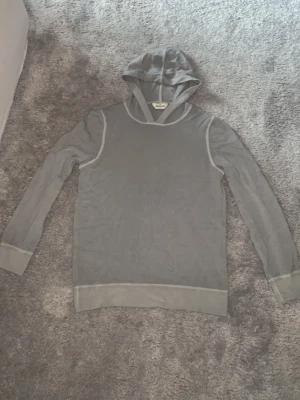 Grå hoodie från Gran Sasso - Stilren grå hoodie från Gran Sasso med långa ärmar och huva. Tillverkad i ett mjukt material med breda muddar vid ärmslut och nederkant. Snygga sömdetaljer längs axlar och ärmar ger en clean look. Hoodien säljs för att den är för liten för mig👍🏻