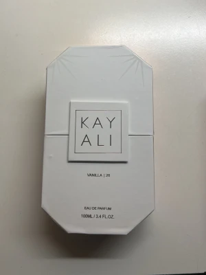 Kayali Vanilla | 28 Eau de Parfum - Kayali Vanilla | 28 Eau de Parfum i en lyxig, åttakantig glasflaska med guld- och kristalldetaljer. Doften är varm och söt med tydlig vaniljton. Förpackningen är vit och stilren, flaskan rymmer 100 ml.