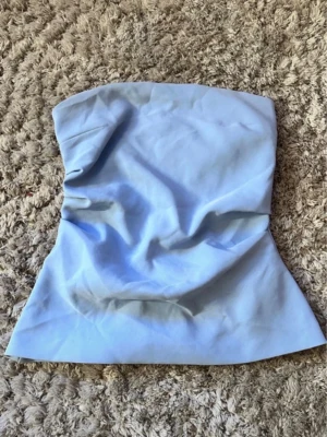 Ljusblå tubtopp Zara - Fin ljusblå offshoulder topp från Zara! Pris kan diskuteras  Se sista bild! (Inget som hindrar dragkedjan) För liten för mig💗 Strl M men tycker mer S