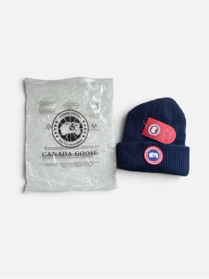 Mörkblå Stickad Mössa med Broderad Patch – Helt Ny i Förpackning - Säljer en stilren mörkblå (navy) stickad mössa med uppvikt kant och klassisk rund broderad logo-patch framtill. Mössan är tillverkad i ett varmt och skönt material, perfekt för kyligare dagar. Helt ny och oanvänd, levereras i plastförpackning med alla lappar och taggar kvar.  Färg: Mörkblå (Navy)  Storlek: One Size  Skick: Helt ny & oanvänd (med taggar) 📦 Skickas snabbt och spårbart! 