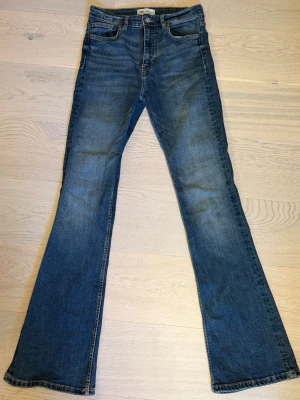 Blå bootcut jeans med hög midja - Säljer ett par jätte snygga highwaist jeans från Zara! Sitter jätte fint och är väldigt sköna!! 