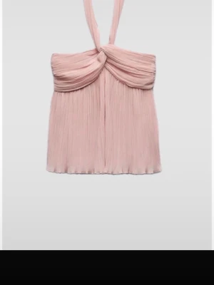 Ljusrosa topp från Zara  - Supersöt ljusrosa halterneck topp med plisserat tyg och twistad detalj framtill. Toppen har en flowy passform och är perfekt för att skapa en romantisk look. Snygg att styla med både jeans och kjol.