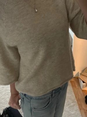 Beige oversized stickad tröja - Mysig beige stickad tröja med oversized passform och rund halsringning. Tröjan har trekvarts ärmar och är tillverkad i ett mjukt material. Använd