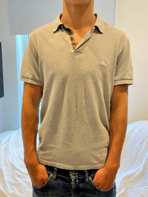 Burberry piké - Burberry piké i ny skick. Storlek M. Killen på bilden är 182 och väger 73kg. Går ner i pris vid snabb affär.