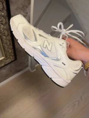 Vita New Balance 408 sneakers - Snygga vita New Balance 408 sneakers med klassisk chunky sula och meshpaneler för extra ventilation. Skorna har silvriga detaljer och den ikoniska N-loggan på sidan. Perfekta för dig som gillar retrostil och streetwear.