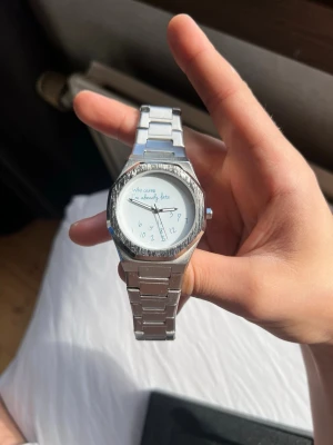 WHO cares im already late 42mm - Stilren klocka i silverfärgad metall med länkarmband och rund vit urtavla. På urtavlan står det 'Who cares I'm already late' och siffrorna är handskrivna i en lekfull stil. Perfekt för dig som gillar humoristiska detaljer i din stil.