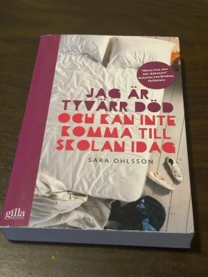 Jag är tyvärr död och kan inte komma - Romanen 'Jag är tyvärr död och kan inte komma till skolan idag' av Sara Ohlsson är en pocketbok med färgstarkt omslag i vitt, rosa och rött. Boken ges ut av Gilla Böcker och handlar om kärlek, vänskap och att hitta sig själv under tonåren.
