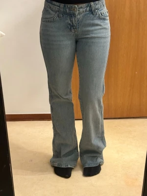 Ljusblå y2k  bootcut jeans med fickor - Säljer ett par ljusblå Y2K bootcut-jeans med låg midja. De har en jättefin passform och är perfekta för en snygg Y2K-inspirerad look, samtidigt som de är enkla att matcha med olika outfits. Jeansen är utan fläckar eller märken och är i väldigt fint skick. Det enda är att de är lite slitna längst ner på baksidan eftersom de varit för långa för mig, men annars är de helt perfekta.💕💕Nypris 499kr