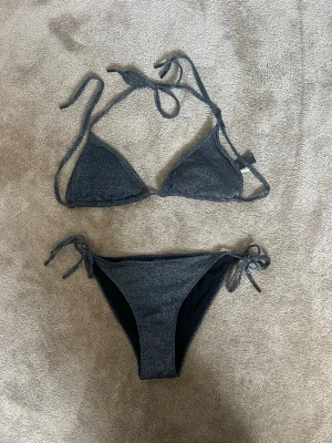 Mörkblå bikini med knyt - Snygg mörkblå trekantsbikini i glittrigt material med knyt i både nacken och ryggen😍