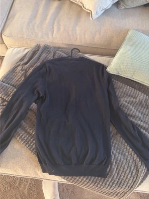 Svart basic tröja med rund hals från dressman storlek s - En enkel svart tröja med rund hals och långa ärmar. Tröjan har en smal passform och ribbade muddar vid ärmslut och nederkant. Perfekt att styla lager på lager eller bära som den är till jeans eller kjol.