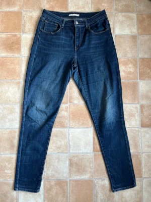 Levi’s High Rise Skinny Jeans | W31 L32⁠ - Säljer ett par snygga klassiska Levi’s jeans i modellen High Rise Skinny! Hög midja och riktigt fin mörkblå tvätt. Tillverkade i skönt stretchigt material som sitter perfekt. #levis #levisjeans #jeans #highrise #skinnyjeans #denim #säljer #plikt #vintage #y2k #mörkblå 