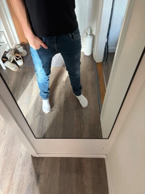 Blå slim fit jeans herr repaly 29/32 - Säljer ett par blå slim fit jeans med klassisk femficksdesign och normal midja. Jeansen har en snygg tvätt och smal passform som sitter tajt längs benen. Perfekta till vardagslooken och funkar året runt.