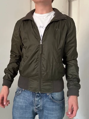 Militärgrön bomberjacka från Alpha Industries - Jacka från Alpha Industries (nypris ca 2000kr). Riktigt cool jacka. Ca storlek XS (trots att det står Medium). Fråga gärna vid funderingar:)