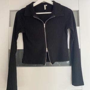 Tröja  - Tröja ifrån Nelly, nyskick. Dragkedjan kan man reglera hur man vill ha den. 