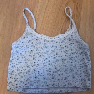 Blommig top!!<3 - En gullig blommig top ifrån brandy Melville!!<3 Rosetten där framme har gått bort men det är inget som jag själv stör mig på!! :) köpt för 180kr på Depop💕