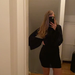 Svart figursydd klänning - Säljer en svart figursydd klänning med volangarmar. Klänningen är aldrig använd så den är i väldigt fint skick. Storlek S men passar även M. 