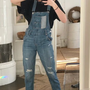 Hängselbyxor - Hängselbyxor med ficka fram och lite slitningar på benen 