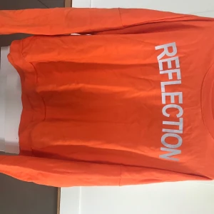 Sweatshirt - Orange sweatshirt med reflekterande text från Istay. Jag brukar vanligtvis ha strl S men använde denna som en klänning.