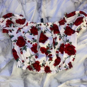 H&m topp - Kort topp med röda rosor. Kan såklart mötas upp men om den ska skickas står köparen för frakten<3